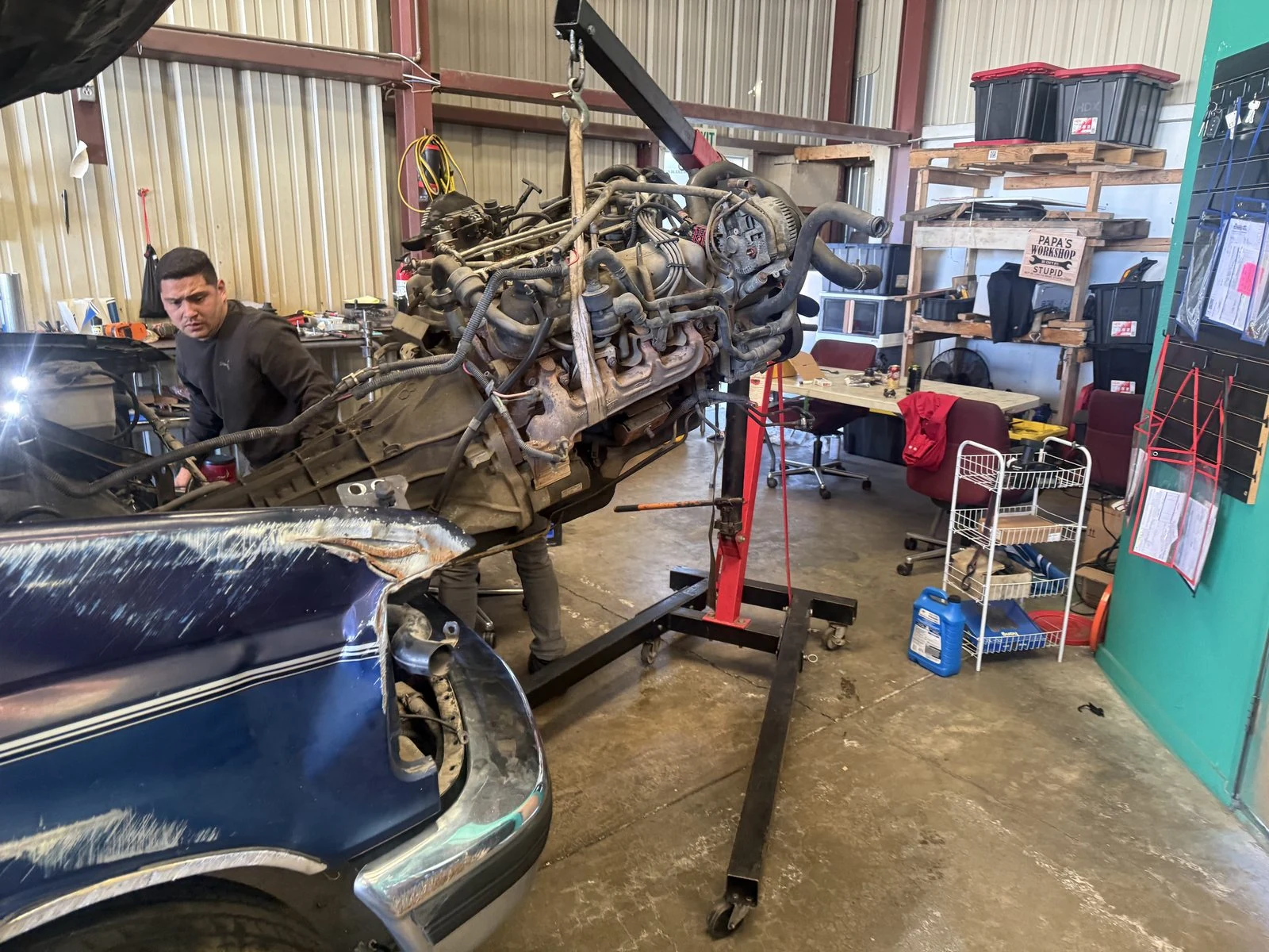 A Supercanic technician beside an engine on the hoist, in our own shop